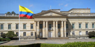 Historic building with Colombia flag in front.