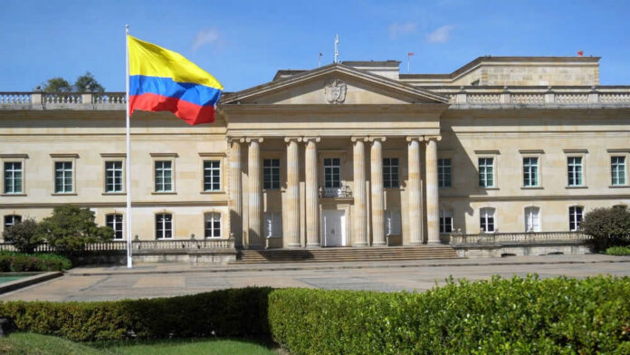 Historic building with Colombia flag in front.
