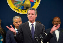 Man speaking at podium with people behind him