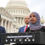 Iran Blitz Sparks MAGA Civil War Three people speaking in front of US Capitol building