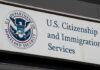 Firefighters Watch Attack — Alarms Explode U.S. Citizenship and Immigration Services building sign.