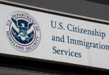 Firefighters Watch Attack — Alarms Explode U.S. Citizenship and Immigration Services building sign.