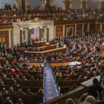 People in a large government assembly hall meeting