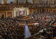People in a large government assembly hall meeting
