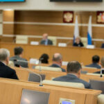 Taxpayer-Funded Lawyers For Migrant Kids? Audience attending a government meeting in a conference room