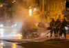Kyiv Blitz Stunner Firefighters extinguishing a car fire on a city street at night