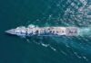 Aerial view of a naval ship navigating through the ocean