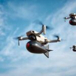 Three drones flying against a blue sky