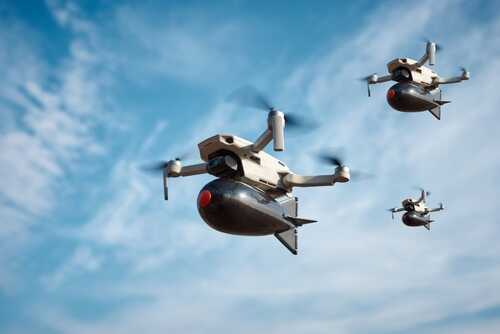 Drones,With,A,Bomb,On,Board,Flies,In,The,Sky Three drones flying against a blue sky