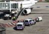 Police vehicles near an airplane at an airport