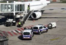 Police vehicles near an airplane at an airport
