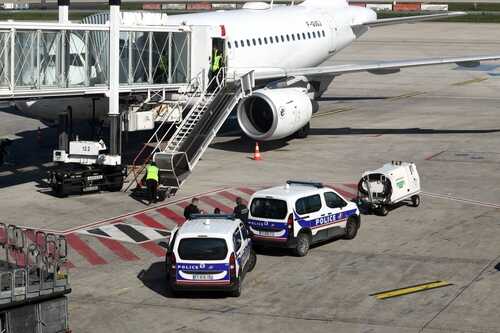 Police vehicles near an airplane at an airport