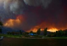 Dramatic sky filled with smoke and fire colors over a lake