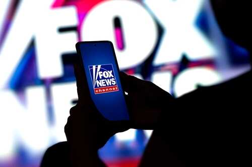 Fox,News,Channel,Logo,On,Mobile,Phone,Screen.,New,York, A person holding a smartphone displaying the Fox News logo against a colorful background