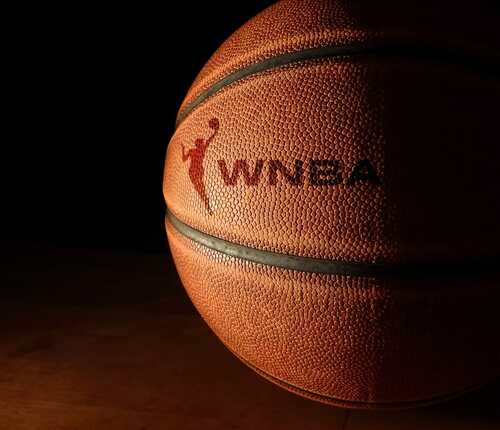 Close-up of a basketball with a logo in low light