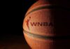 Faith Filter Sparks WNBA Firestorm Close-up of a basketball with a logo in low light