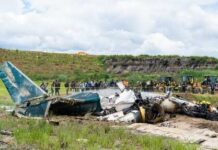 Wreckage of a crashed airplane with emergency responders and onlookers