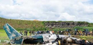 Wreckage of a crashed airplane with emergency responders and onlookers