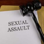 A court gavel resting on a document labeled 'SEXUAL ASSAULT'