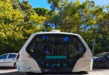 Waymo Car Commits “Hit & Run” An autonomous shuttle vehicle parked on a city street surrounded by trees