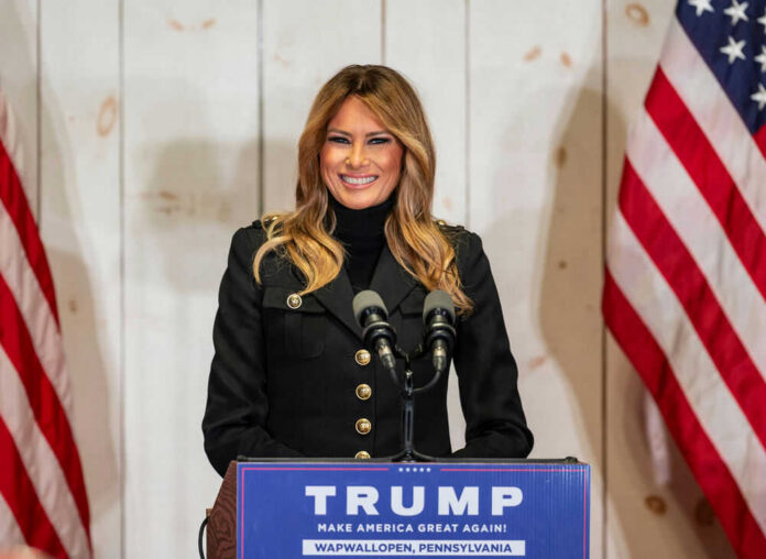 1844845672 Woman speaking at podium with American flags.