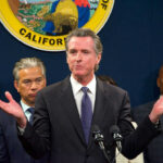 Man speaking at podium with people behind him
