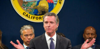 Man speaking at podium with people behind him