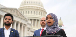 Three people speaking in front of US Capitol building