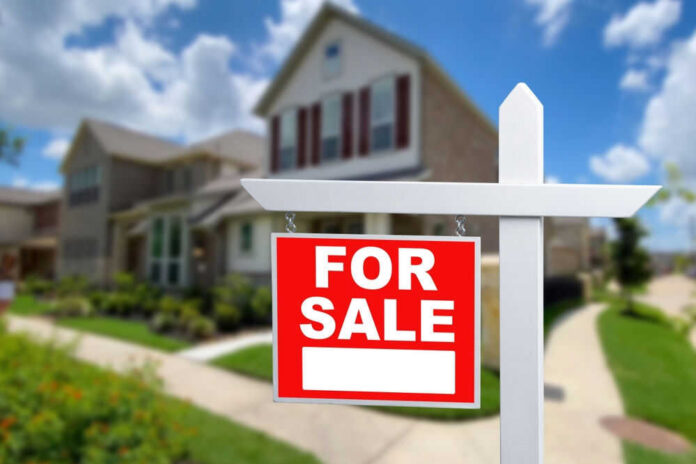For sale sign in front of house