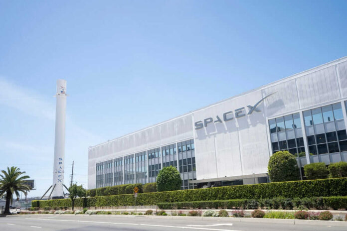 SpaceX building with rocket and palm tree outside