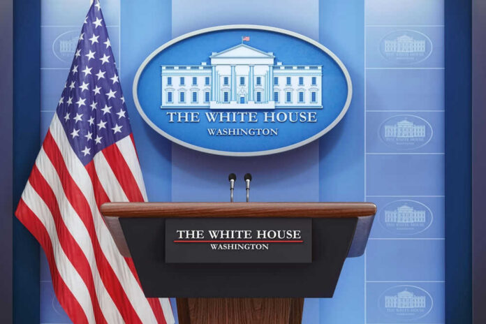 2415827183-1 Podium with microphones in front of American flag