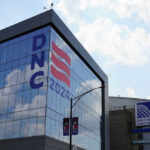 Building with DNC 2024 sign reflected in glass.