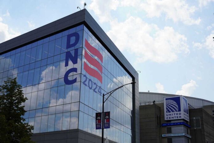 2504121051 Building with DNC 2024 sign reflected in glass.
