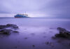 Bering Sea Miracle—Then The Bodies Ship on calm sea with rocky foreground