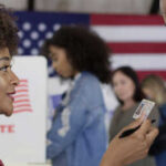 CNN Host’s ‘Gross’ Jab Ignites Michigan Firestorm A woman showing her ID to a man at a voting station