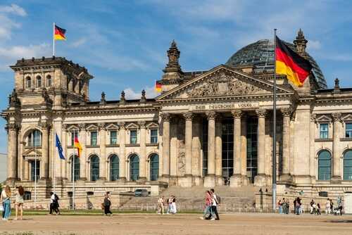Berlin,Germany,May,31,,2025:,View,Of,The,Reichstag,Building The Reichstag building in Berlin with German flags and people walking in front