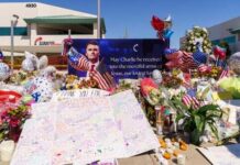 A memorial with flowers, balloons, and a tribute banner honoring someone named Charlie